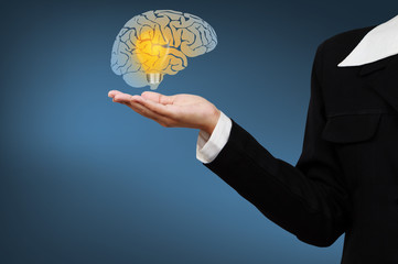 Businessman show brain with Light Bulb in palm.