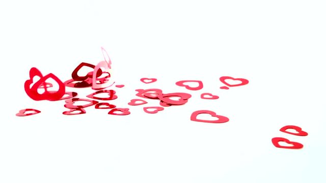 Shiny red Valentine's Day hearts falling and bouncing in reverse from white background