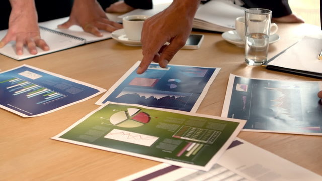 Graphics on table looked by business people in meeting