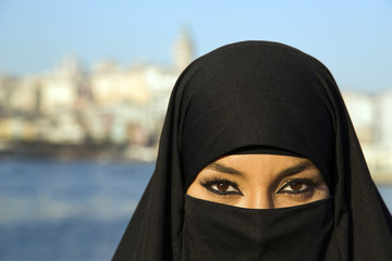 Woman dressed with black headscarf, chador on istanbul street, turkey