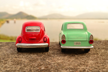 Red and green toy car park couple on the road