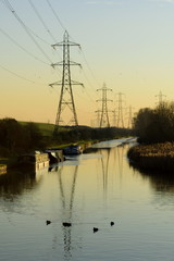 Transmission towers around river Lea at sunset