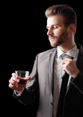 handsome stressed businessman in formalwear holding a glass