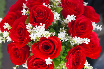 red roses from artificial flowers and white flowers in vase