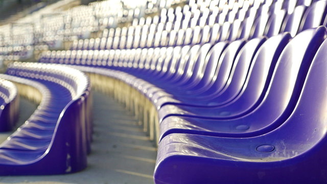 Rows of violet plastic seats on stadium tribune