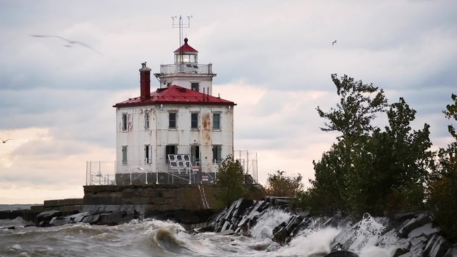 Built in 1925, Ohio's Fairport Harbor West Breakwater Lighthouse shines its light on a blustery day as seagulls fly about.