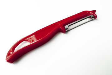 red potato peeler on white background