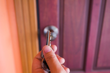 Hand hold a key with blurred door background