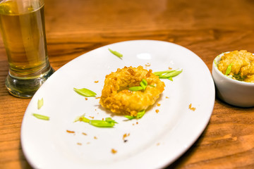 Glass of beer and the remains of squid in batter. The remains of a sumptuous dinner