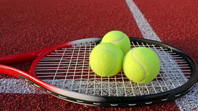 hand puts three tennis balls on Tennis racke
