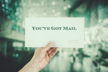 Female hand delivering an envelope on blurred background