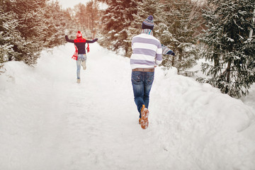 Snowball fight. Winter loving couple having fun playing catch up