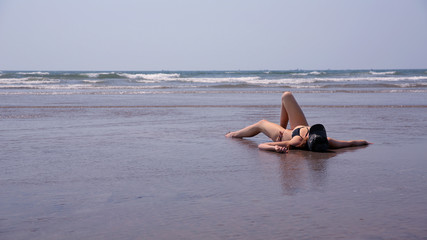Fototapeta na wymiar Young woman relaxing sandy beach