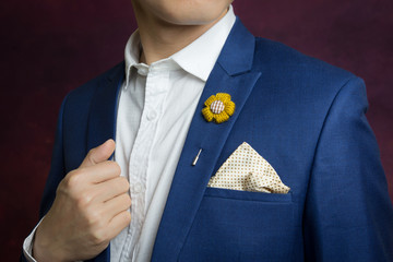 man in blue suit, brooch, handkerchief