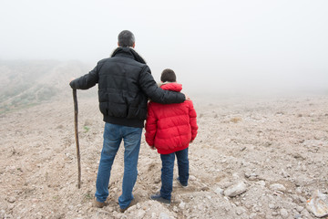 Concept of family escaping.  Father and son in a mountain road w