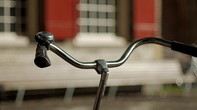 Handlebars of a traditional dutch cycle as cyclists ride past in Amsterdam. Shot in 4K