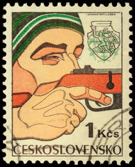 Man shooting a gun on post stamp