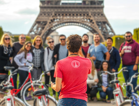 Fototapeta PARIS, FRANCE - AUGUST 30, 2015: Man photographs big group of tourists against Eiffel Tower in Paris. France.