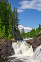 Fototapeta na wymiar waterfalls between rocks with green trees