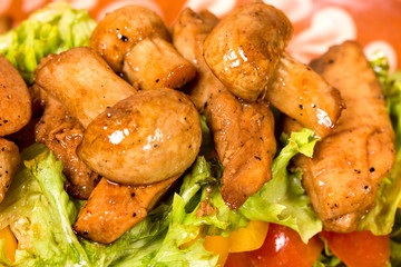 Warm pork salad with mushrooms.