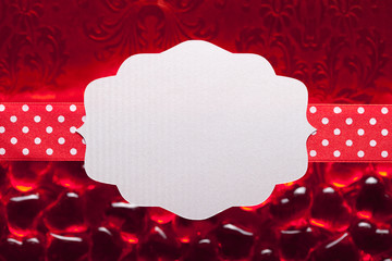 Blank label and ribbon on red background