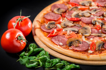 closeup Tasty pizza with tomatoes, mushroom, sausage, basil and