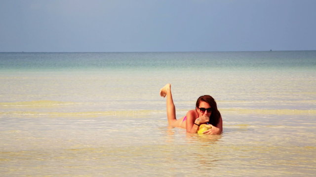 Woman sunbathing crystal water drinking coconut enjoying vacation, cambodia