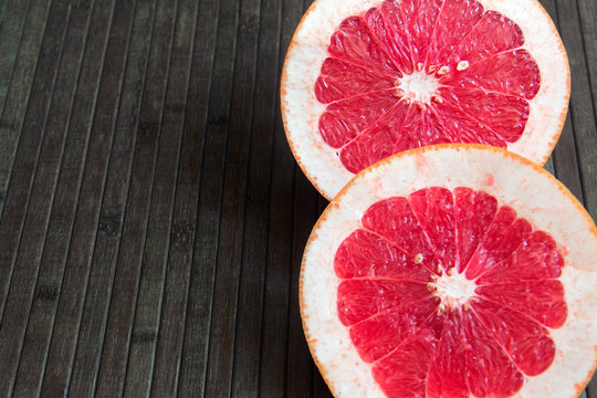 grapefruit cut in half on a wooden brown background