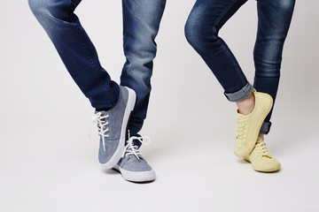 Sibling in sneakers and jeans in studio