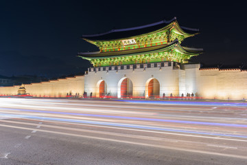 Traffic blurs past Gyeongbokgung palace at night in Seoul, South