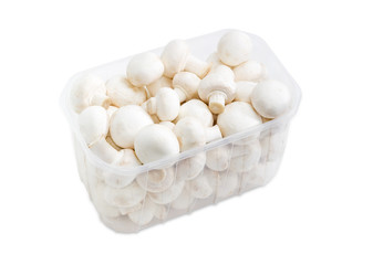 Button mushrooms in a plastic tray on a light background