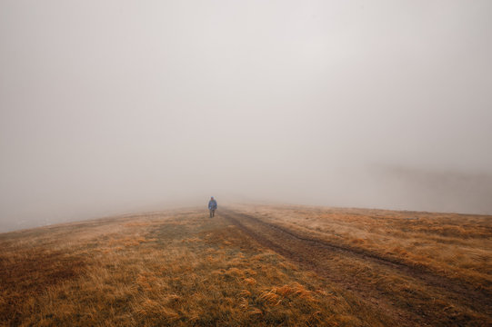 Fototapeta man walking out of fog