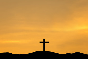 The cross on top a mountain at sunset