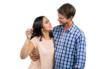 Cheerful couple embracing while holding keys