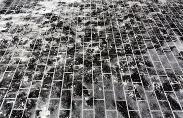Snow on pavement stones.