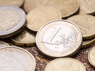 Euro coins over the old world map.