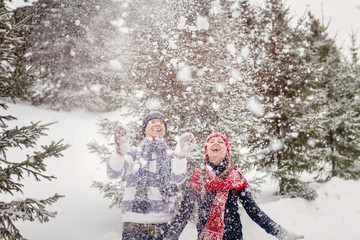Young woman and man playing with snow
