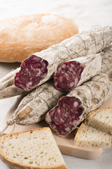 Some Italian sausages arranged on a cutting board with bread, selective focus.