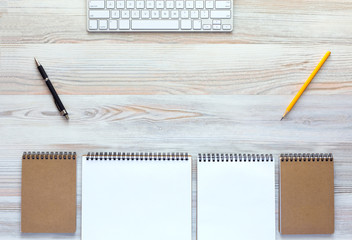 Top view of light wooden Desk with Keyboard and stationery