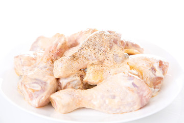 raw chicken drumsticks on white background