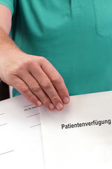 Patientenverfügung/Arzt im OP-Kittel mit Patientenverfügung