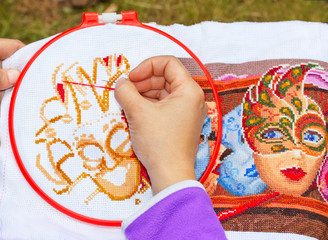 
Woman embroidering a picture of a cross on the hoop
