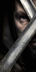 Viking warrior in hood with moustache, borded looking throught t