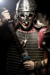 Shouting viking with sword and helmet over black background