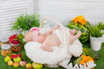 Fototapeta na wymiar newborn in basket with fruits and vegetables