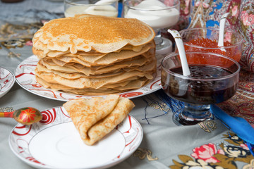 Pancakes with red caviar, jam, cream and tea during Shrovetide
