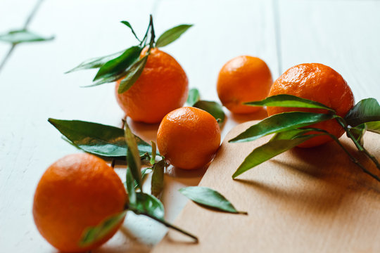 Beautiful ripe tangerines with leaves on white wooden table