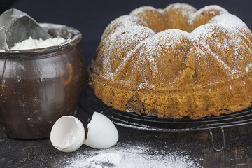 Rührkuchen mit Puderzucker und Backutensilien