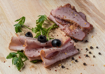 Ham pieces with black olives and spices