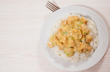 Pieces of chicken fillet and cheese sauce with rice